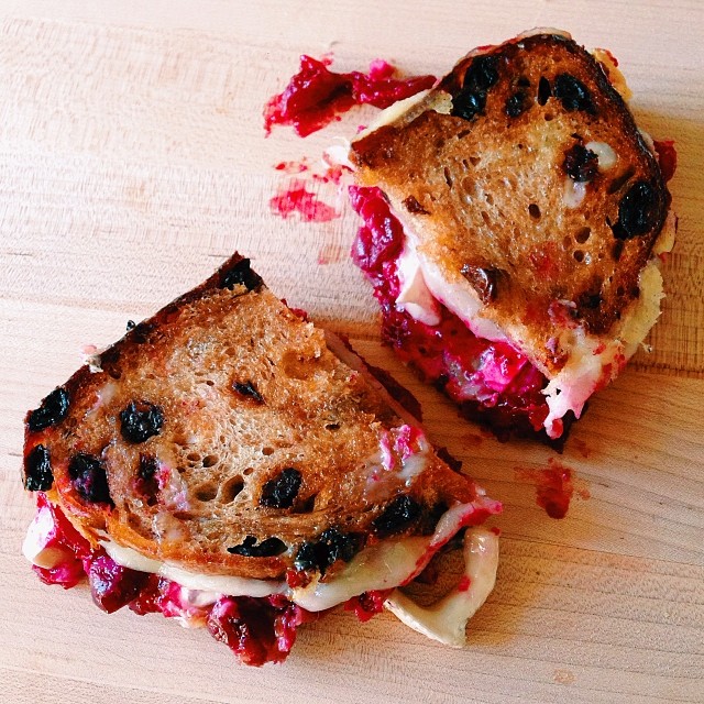 leftover cranberry sauce with white cheddar + brie on cinnamon raisin bread grilled cheese