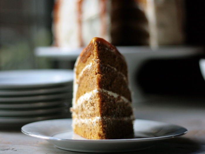 pumpkin spice layer cake with cream cheese frosting, standing up on white plate