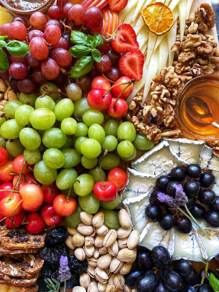 california cheese board with red green and black grapes